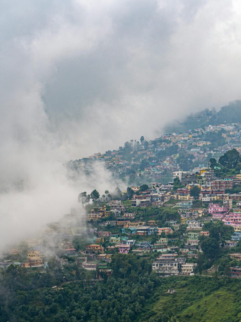 A breathtaking aerial view of misty Almora, India nestled in lush mountains.